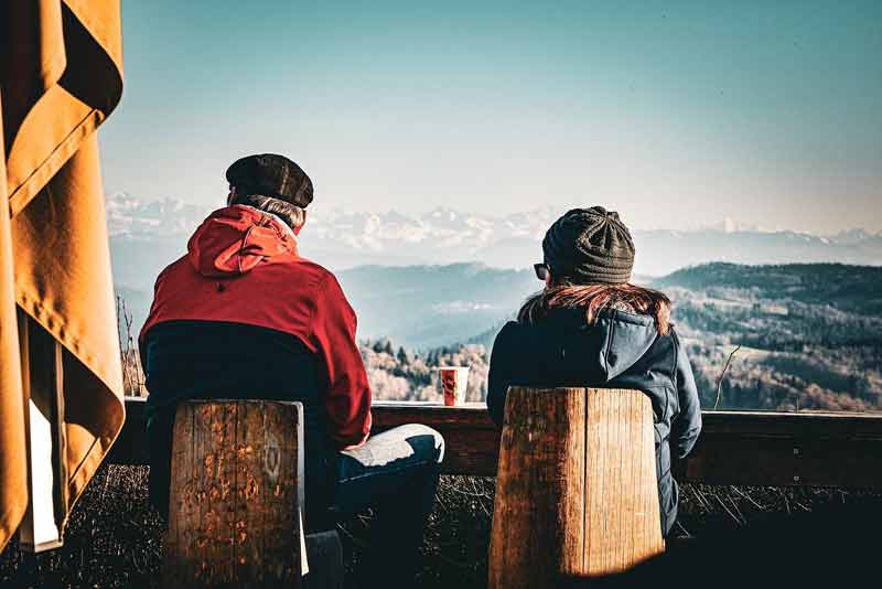 Couple qui boit un café en admirant la vue sur les Alpes suisses depuis l’Uetliberg à Zurich
